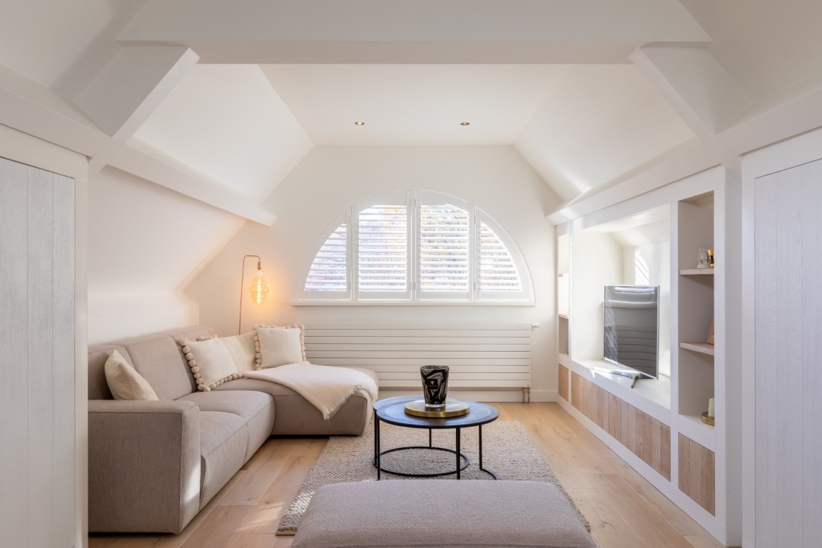 Lichte woonkamer met witte open shutters in Brecht