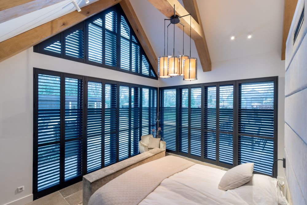 Zwarte shutters op zwarte kozijnen in slaapkamer