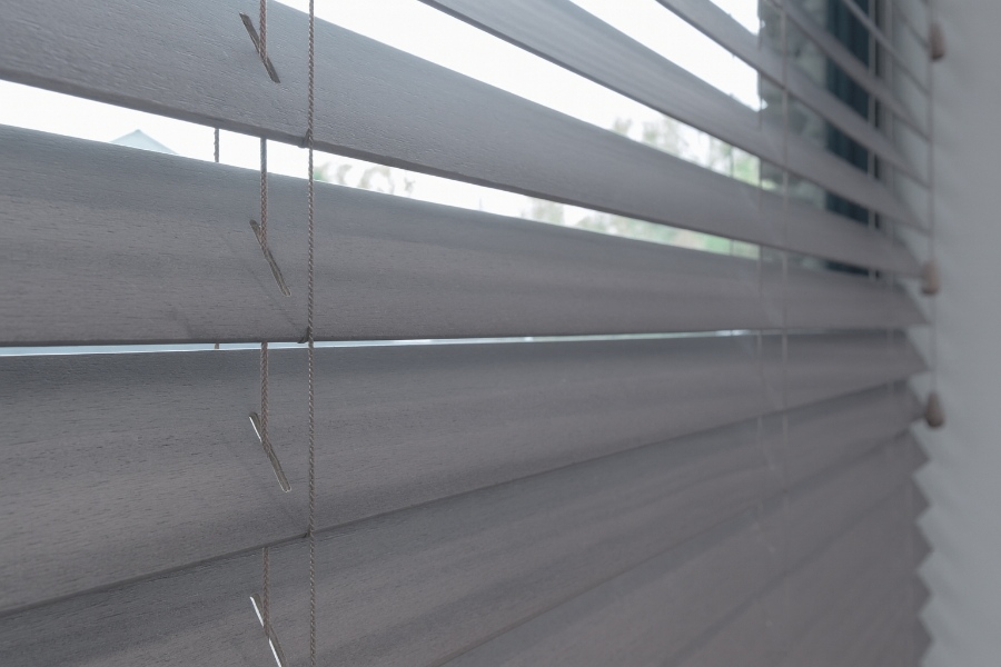 Grijze jaloezieën van hout als raambekleding